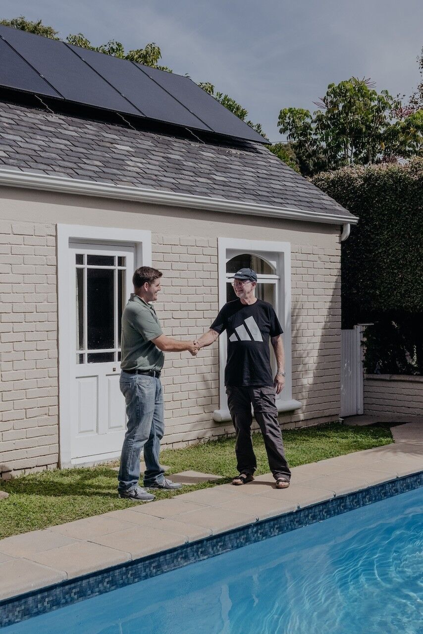 Nick shaking hands with a client beside a pool